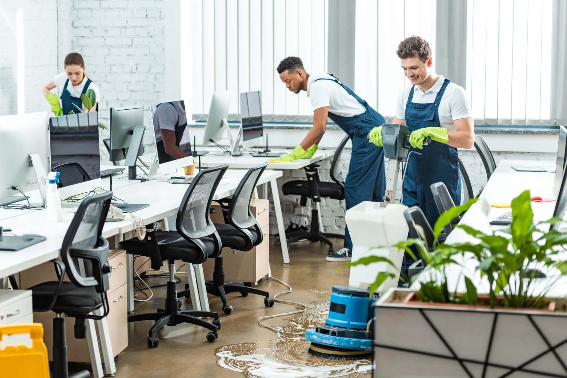 Multicultural team of professional cleaners working in a modern open office